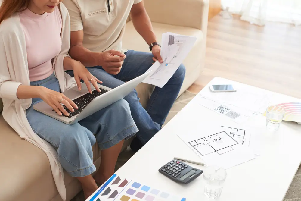 Homeowners reviewing basement remodel plans and budget to avoid unexpected renovation costs.