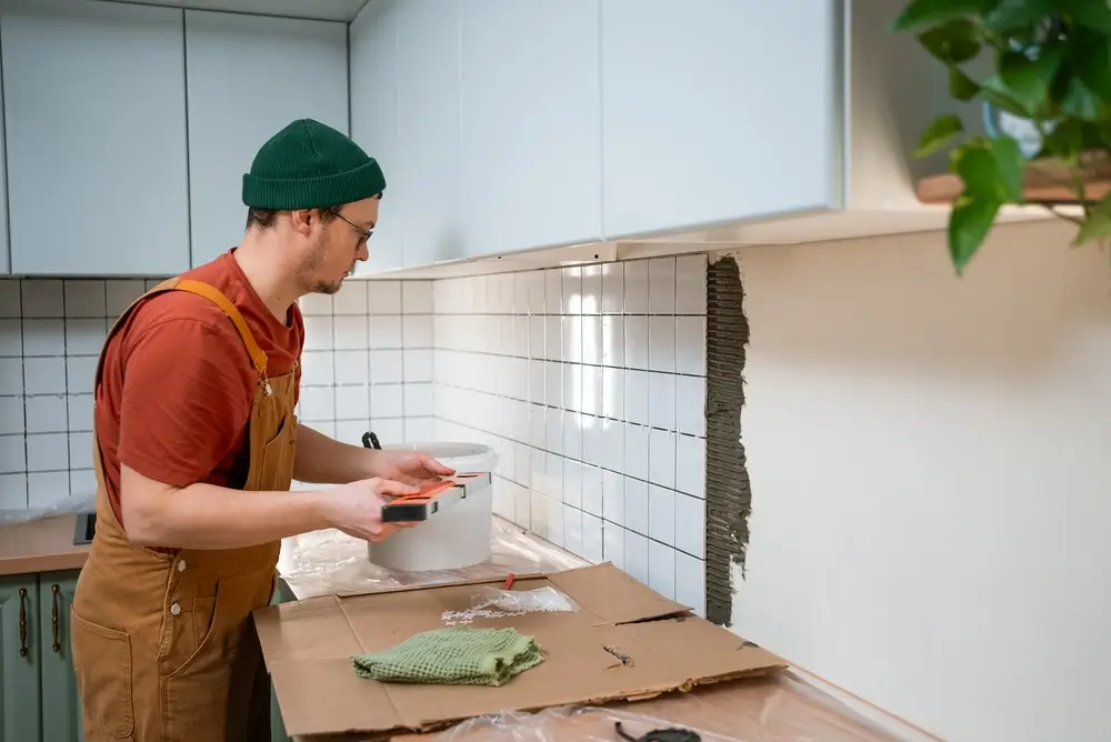 Contractor installing tile during a basement remodeling project to improve a finished basement.